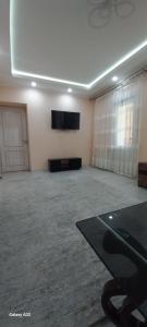 een grote kamer met een flatscreen-tv aan de muur bij Апартаменты in Tasjkent