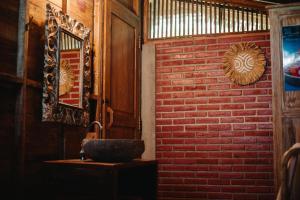 ein Badezimmer mit einer Ziegelwand und einem Waschbecken in der Unterkunft Nauna Villa Bali in Ubud