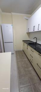 een keuken met witte kasten en een witte koelkast bij Апартаменты in Tasjkent