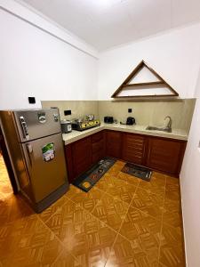 una cucina con frigorifero in acciaio inox e mobili in legno di Lagoonlike Hiriketiya a Dikwella