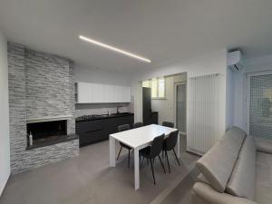 een keuken en woonkamer met een witte tafel en stoelen bij B&B Relais in Francavilla al Mare