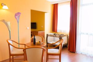 a living room with a table and chairs and a crib at Karos Gold 813 Wellness Apartman in Zalakaros
