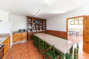 una cucina con tavolo e sedie verdi in una stanza di El Pongallin a Sevares
