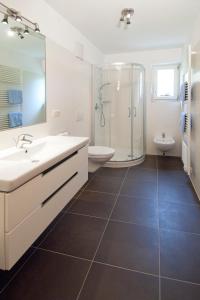 bagno con doccia, lavandino e servizi igienici di Obermaratscher Apartments Residence a Lagundo