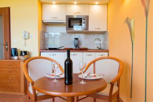 a kitchen with a table and two glasses of wine at Karos Gold 813 Wellness Apartman in Zalakaros
