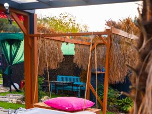 a pergola with a bench and a pink pillow under it at Palmera suit in Sapanca