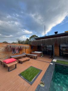 a wooden deck with benches and a swimming pool at Palmera suit in Sapanca