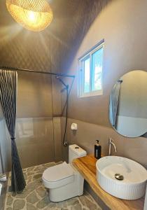 ein Badezimmer mit Waschbecken, Toilette und Spiegel in der Unterkunft Mangoverde Guesthouse in Moalboal