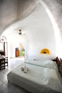 1 dormitorio con 1 cama con 2 toallas en Kavalari Hotel - Adults Only en Fira