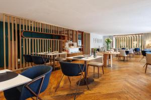 a restaurant with tables and chairs in a room at Lasala Plaza Hotel - Adults Only in Donostia-San Sebastián