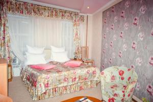 a bedroom with a bed and a chair at Hotel Atlantida in Kislovodsk