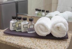 a bathroom counter with two bottles of soap and towels at The Kensington Hotel in Ann Arbor +20 photos