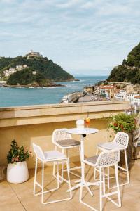 a table and chairs on a balcony with a view of the ocean at Lasala Plaza Hotel - Adults Only in Donostia-San Sebastián