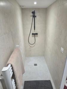 een badkamer met een douche met een douchekop bij Les Noisetiers appartement in Saint-Just-Malmont