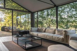 a living room with a couch and a table at Glass House & SPA - DCA Certified - in Terruggia