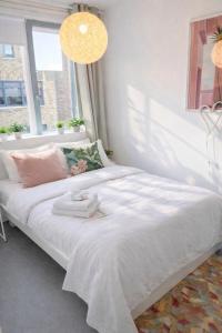 a white bed in a room with a window at Canal House - Homestay in Alkmaar