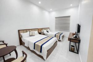 a hotel room with two beds and a television at Điêu Thuyền Hotel Bến Tre in Ben Tre
