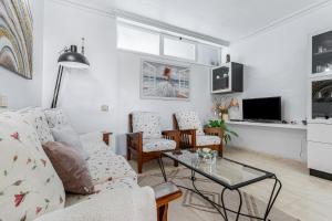 ein Wohnzimmer mit Sofa und Tisch in der Unterkunft Mar Y Sol in Caleta de Fuste