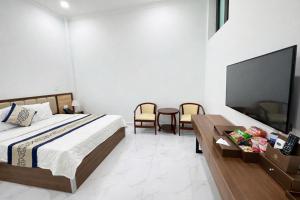 een slaapkamer met een bed en een flatscreen-tv bij Điêu Thuyền Hotel Bến Tre in Ben Tre +20 foto's