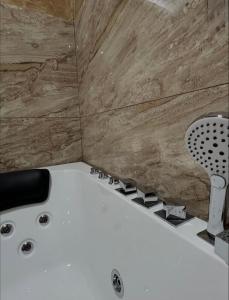 een badkamer met een wit bad en houten wanden bij Sobe i Apartmani Casa Mia in Pećinci