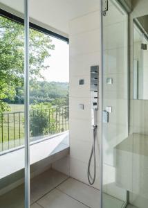 y baño con ducha de cristal y ventana. en Glass House & SPA - DCA Certified - en Terruggia