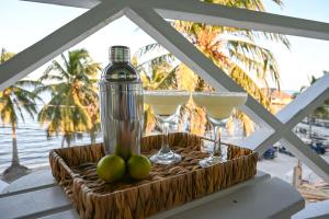 a tray with two martini glasses and a bottle at The Palapa House in San Pedro