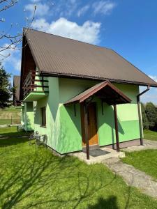 een groen gebouw met een bruin dak bij Agroturystyka u Dudków- Balia i Apiterapia in Jeleśnia +6 foto's