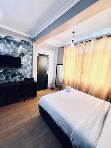 a bedroom with a bed and a desk in a room at Rejis Hotel in Dodoma