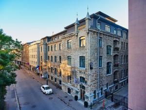 une voiture blanche garée devant un grand bâtiment en briques dans l'établissement Hotel St. Barbara, à Tallinn