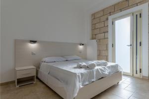 een slaapkamer met een wit bed met handdoeken erop bij La casetta b&b in Ceraso