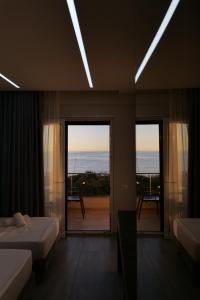 een slaapkamer met 2 bedden en uitzicht op de oceaan bij The Blue Wave Hotel in Himare