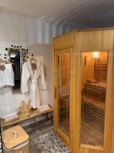 a dressing room with a wooden cabinet with a robe at Ô Dream Spa in Le Val
