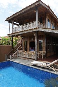 ein Haus mit einem Swimmingpool vor dem Haus in der Unterkunft Nauna Villa Bali in Ubud