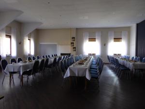 a large room with tables and chairs with white tablecloths at Landgasthof Schneller in Katzwinkel