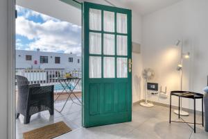 a green door in a room with a patio at Carpe Diem Apartment - Pool view By Lanzarote Vacation Homes in Puerto del Carmen +20 photos