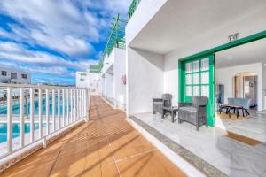 a view from the balcony of a house with a swimming pool at Carpe Diem Apartment - Pool view By Lanzarote Vacation Homes in Puerto del Carmen