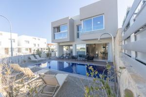 a house with a swimming pool in front of a house at Mythical Blue Villas in Protaras