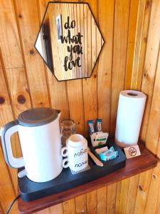 a shelf with two coffee mugs and a sign on a wall at Apartmani Božana Vojinović in Žabljak