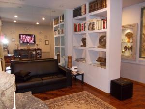 uma sala de estar com um sofá e prateleiras de livros em Luxury ai Banchi Nuovi em Roma