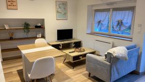 a living room with a couch and a table and a tv at Charmante maison in Pleumeleuc