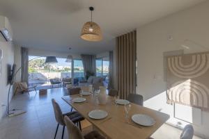 a dining table and chairs in a living room at Mythical Blue Villas in Protaras