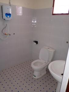 a bathroom with a white toilet and a sink at The Lakeside Beach Hotel in Busia