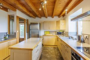 une grande cuisine avec des plafonds en bois et des comptoirs en bois dans l'établissement Gite de Marbois, 