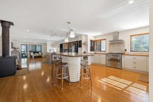 een grote keuken met een bar met krukken erin bij Narrawallee Oasis in Narrawallee