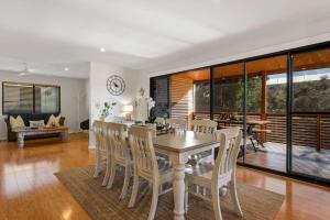een eetkamer en woonkamer met een tafel en stoelen bij Narrawallee Oasis in Narrawallee