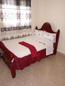 a bedroom with a bed with a red blanket on it at The Lakeside Beach Hotel in Busia +7 photos