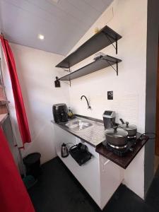 een kleine keuken met een fornuis en een spoelbak bij Chalé Black no Sul da Ilha in Florianópolis