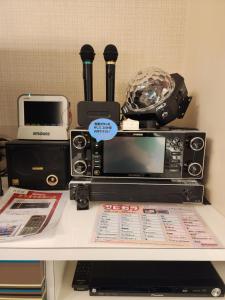 een tafel met een magnetron en andere elektronische apparaten erop bij ホテルメイプル in Odate +2 foto's