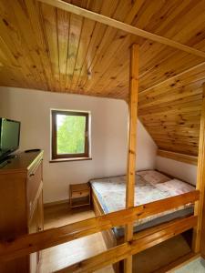 een slaapkamer met een stapelbed in een blokhut bij Agroturystyka u Dudków- Balia i Apiterapia in Jeleśnia