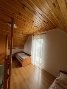 een zolderkamer met een bed en een raam bij Agroturystyka u Dudków- Balia i Apiterapia in Jeleśnia